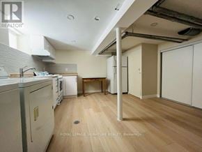 Toronto (East York) apartment for rent - A kitchen with a dining table and a washing machine.
