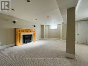 Toronto (East York) apartment for rent - A living room with a fireplace and carpeted floor.