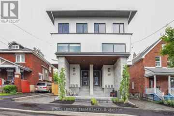 Ottawa apartment for rent - A white two-story house with a balcony on the second floor is for sale.