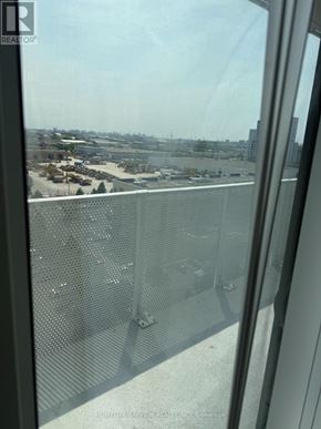Oshawa (Windfields) condo for rent - A view from a high-rise building looking out over a parking lot and other buildings.