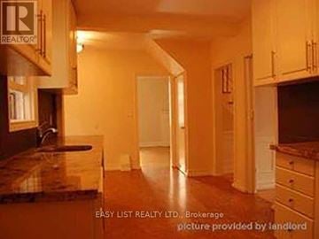 Toronto (Bedford Park-Nortown) duplex for rent - A real estate listing image of a kitchen with wooden cabinets and a marble countertop.