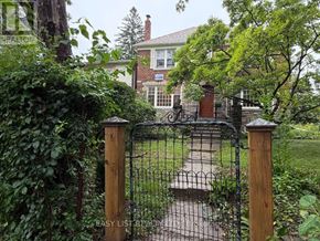 Toronto (Bedford Park-Nortown) multi-family for rent - A black wrought iron gate with a wooden post on either side.