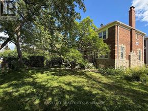 Toronto (Bedford Park-Nortown) multi-family for rent - A red brick house with a chimney and a green lawn in front.