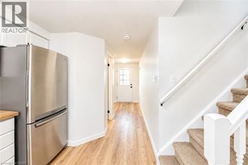 Waterloo apartment for rent - A stainless steel refrigerator sits in a kitchen with wooden floors and white walls.