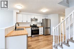 Waterloo apartment for rent - A kitchen with white cabinets and a wooden countertop.