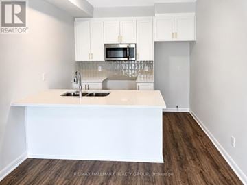 Ottawa townhouse for rent - A kitchen with white cabinets and a white island.