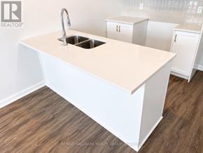 Ottawa townhouse for rent - A white kitchen island with a sink and cabinets in the background.