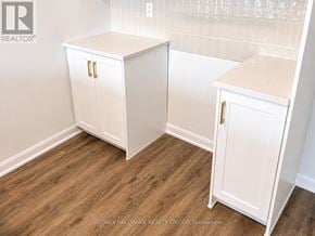 Ottawa townhouse for rent - Two white cupboards in a room with wooden flooring.