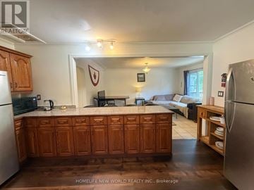 London East (East B) apartment for rent - A kitchen with wooden cabinets and a white refrigerator.