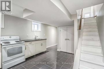 Toronto (Trinity-Bellwoods) apartment for rent - A white kitchen with a stove top oven and a staircase.
