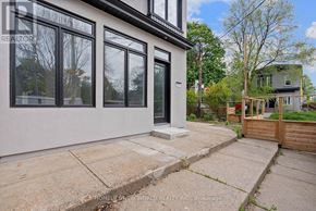 Toronto (Greenwood-Coxwell) apartment for rent - A modern house with a white exterior and large windows.