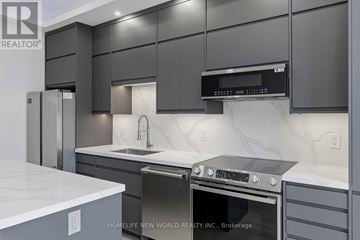 Toronto (Greenwood-Coxwell) apartment for rent - A modern kitchen with dark grey cabinets and stainless steel appliances.