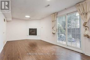 Toronto (L'amoreaux) townhouse for rent - A large, empty room with a fireplace and sliding glass doors.