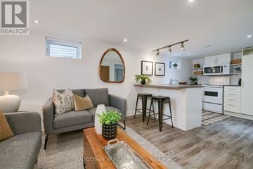 Toronto (Greenwood-Coxwell) apartment for rent - A modern living room with a grey couch and a wooden coffee table.