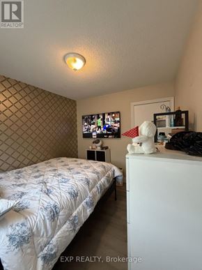 Welland (N. Welland) apartment for rent - A bedroom with a bed, a TV, and a wall with a diamond pattern.