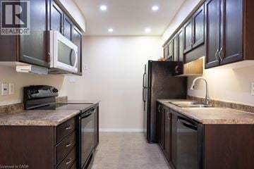 Kitchener townhouse for rent - A kitchen with brown cabinets and a granite counter top.