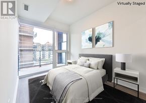 Mississauga (Port Credit) condo for rent - A bedroom with a large bed and a painting on the wall.