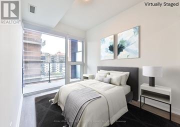 Mississauga (Port Credit) condo for rent - A bedroom with a large bed and a painting on the wall.