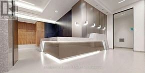 Toronto (Waterfront Communities) condo for rent - A modern office lobby with a glass wall and a reception desk.