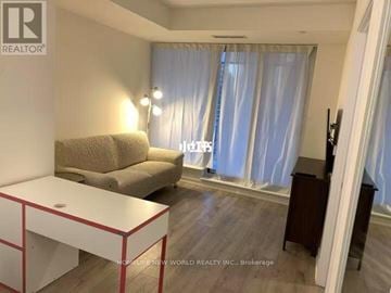 Toronto (Waterfront Communities) condo for rent - A living room with a white table and a beige couch.