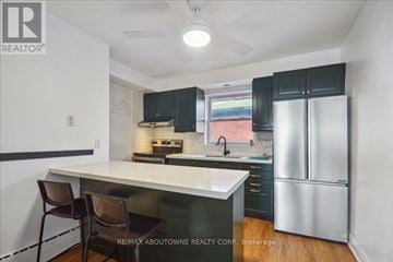 Toronto (Mimico) multi-family for rent - A kitchen with a white counter top and black cabinets.