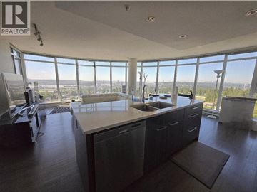 Coquitlam apartment for rent - A modern kitchen with a large island and a view of the city.