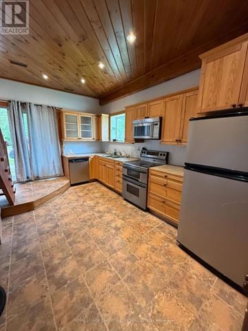 Mono multi-family for rent - A kitchen with wooden cabinets and a black refrigerator.