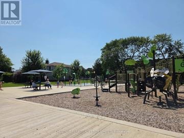 Oshawa (Lakeview) condo for rent - A playground with a slide, swings, and a seesaw.