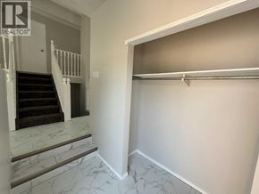Lloydminster apartment for rent - A hallway with a marble staircase and a white wall.
