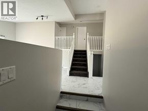 Lloydminster apartment for rent - A staircase with a white railing and a black carpeted bottom step.
