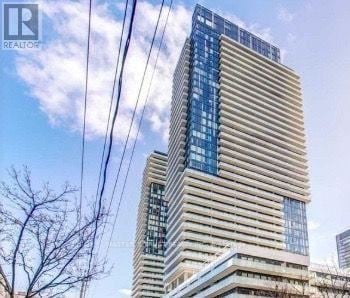 Toronto (Mount Pleasant West) condo for rent - A tall building with a beige facade and blue glass windows.
