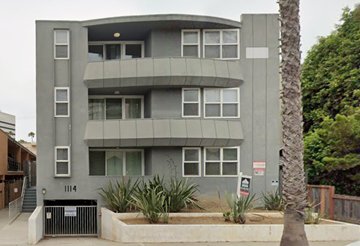 Santa Monica apartment for rent - A grey building with a palm tree in front.
