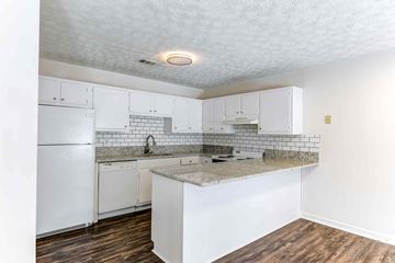 Cornelia apartment for rent - A kitchen with white cabinets and a white refrigerator.
