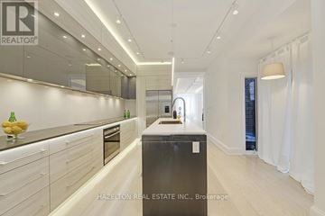 Toronto (Annex) apartment for rent - A modern kitchen with white cabinets and a black refrigerator.