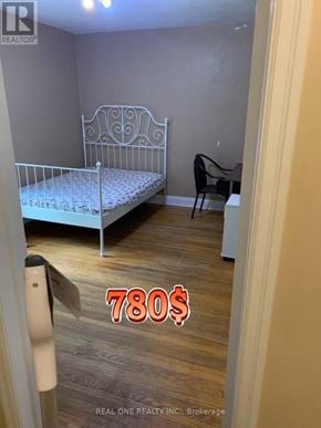 Hamilton (Ainslie Wood) apartment for rent - A bedroom with a bed, chair, and a price tag of 780$.