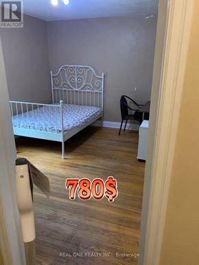 Hamilton (Ainslie Wood) apartment for rent - A bedroom with a bed, chair, and a price tag of 780$.