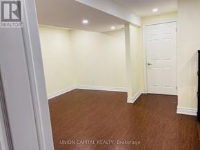 Oshawa (Taunton) apartment for rent - A room with wooden flooring and white walls, with a door on the right side.