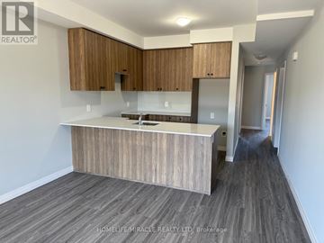 Kitchener townhouse for rent - A kitchen with wooden cabinets and a countertop.