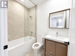 Vaughan (Vaughan Corporate Centre) condo for rent - A bathroom with a toilet, sink, and mirror.
