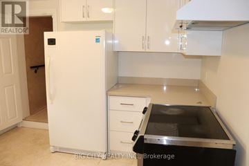 Toronto (Ionview) apartment for rent - A white refrigerator with a black stove top oven in a kitchen.