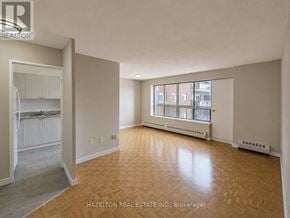 Toronto (Mount Olive-Silverstone-Jamestown) condo for rent - A room with wooden flooring and a window with a view of a building outside.