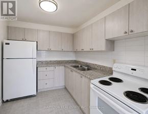 Toronto (Mount Olive-Silverstone-Jamestown) condo for rent - A kitchen with white appliances and cabinets.
