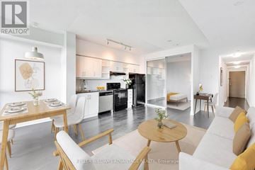 Toronto (Thorncliffe Park) condo for rent - A modern kitchen with white cabinets and a dining table with chairs.