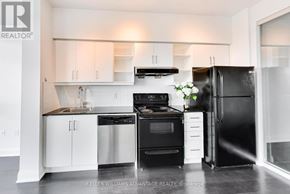 Toronto (Thorncliffe Park) condo for rent - A modern kitchen with a black refrigerator and white cabinets.