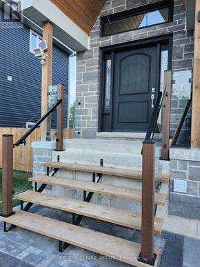 Oro-Medonte apartment for rent - A set of wooden stairs with a black railing leading to a black door.