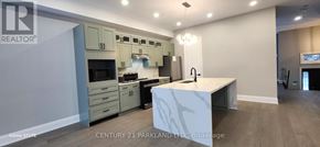 Oro-Medonte apartment for rent - A modern kitchen with a marble island and stainless steel appliances.