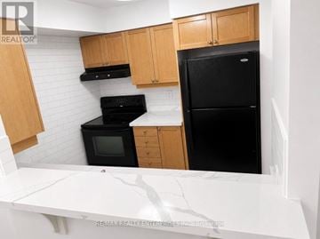 Toronto (West Humber-Clairville) condo for rent - A kitchen with a black fridge, black oven, and black microwave.