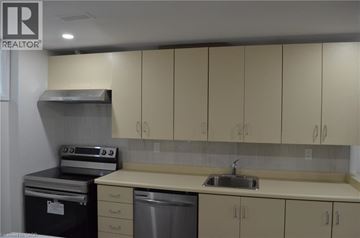 Hamilton apartment for rent - A kitchen with beige cabinets and a stainless steel dishwasher.