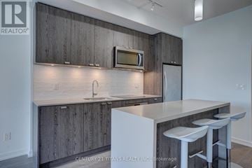 Toronto (Henry Farm) condo for rent - A kitchen with wooden cabinets and a white countertop.