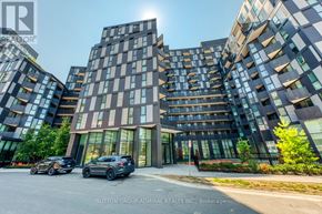 Toronto (Clanton Park) condo for rent - A modern multi-story building with cars parked in front.
